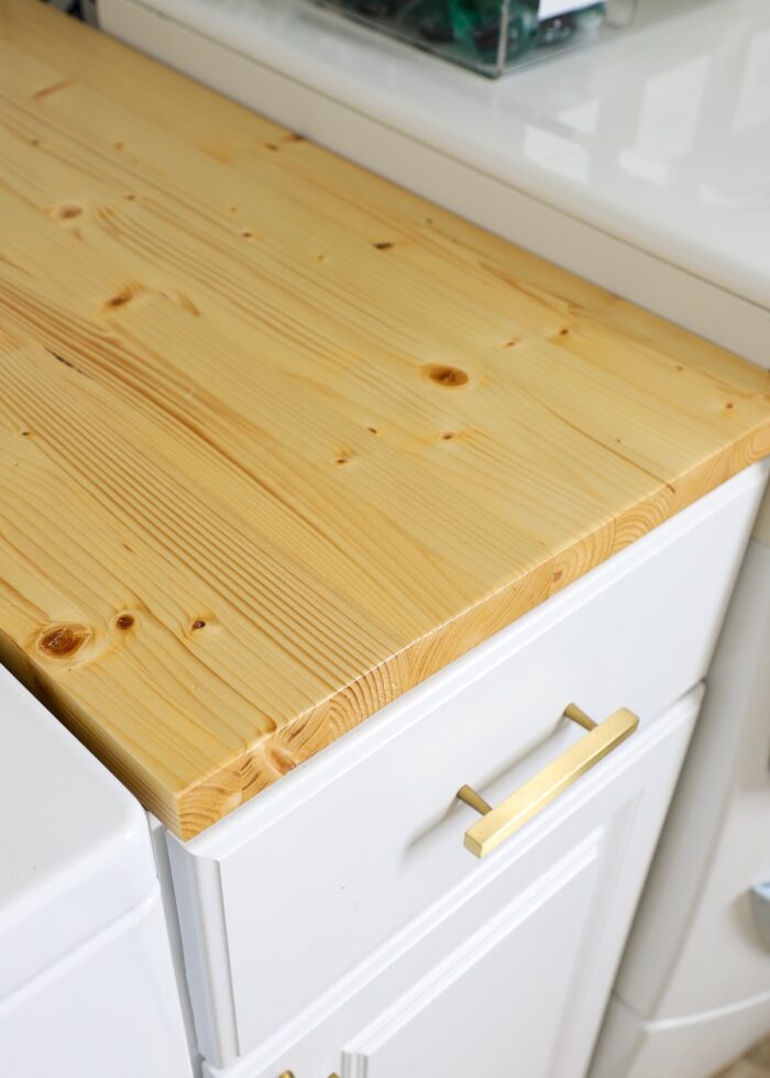Simple wooden countertop on a skinny lower cabinet in a laundry room