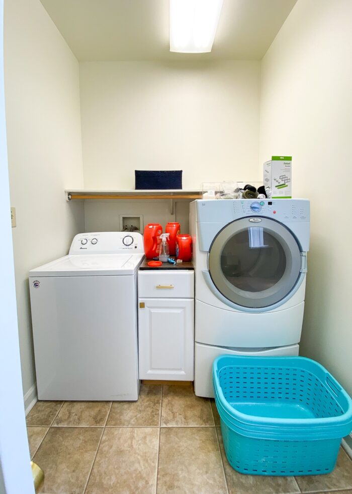 Messy and cluttered laundry room with mis-matched washer and dryer