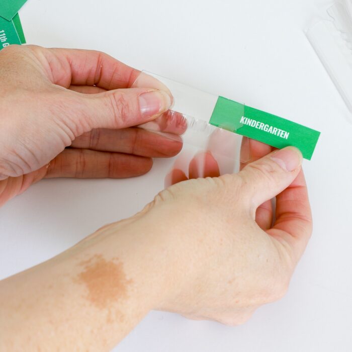 Folded label being inserted into plastic file tab