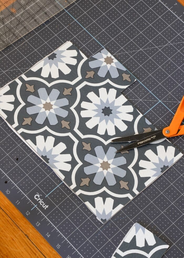 Trimmed down peel and stick floor tile shown next to scissors