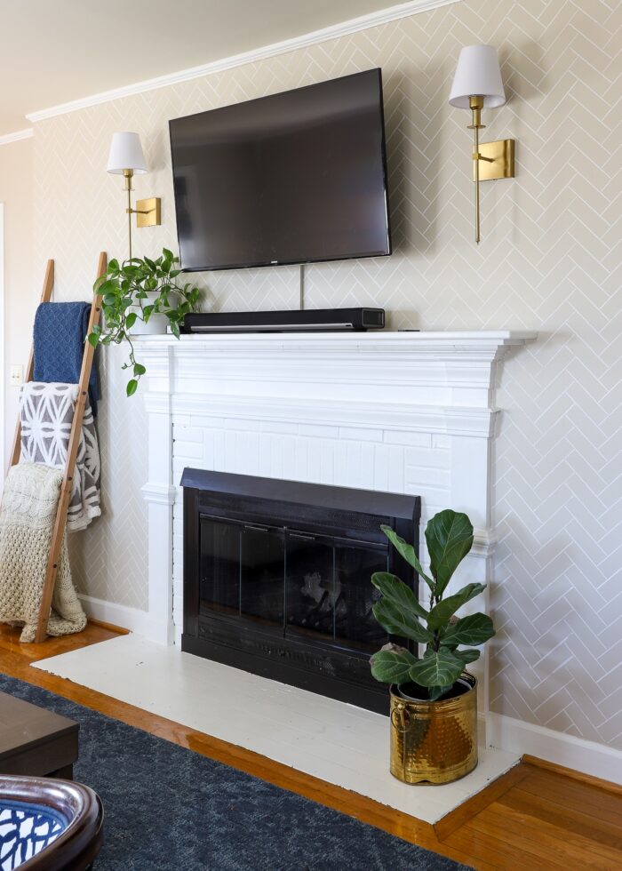 White brick rental fireplace with white mantel and TV mounted above