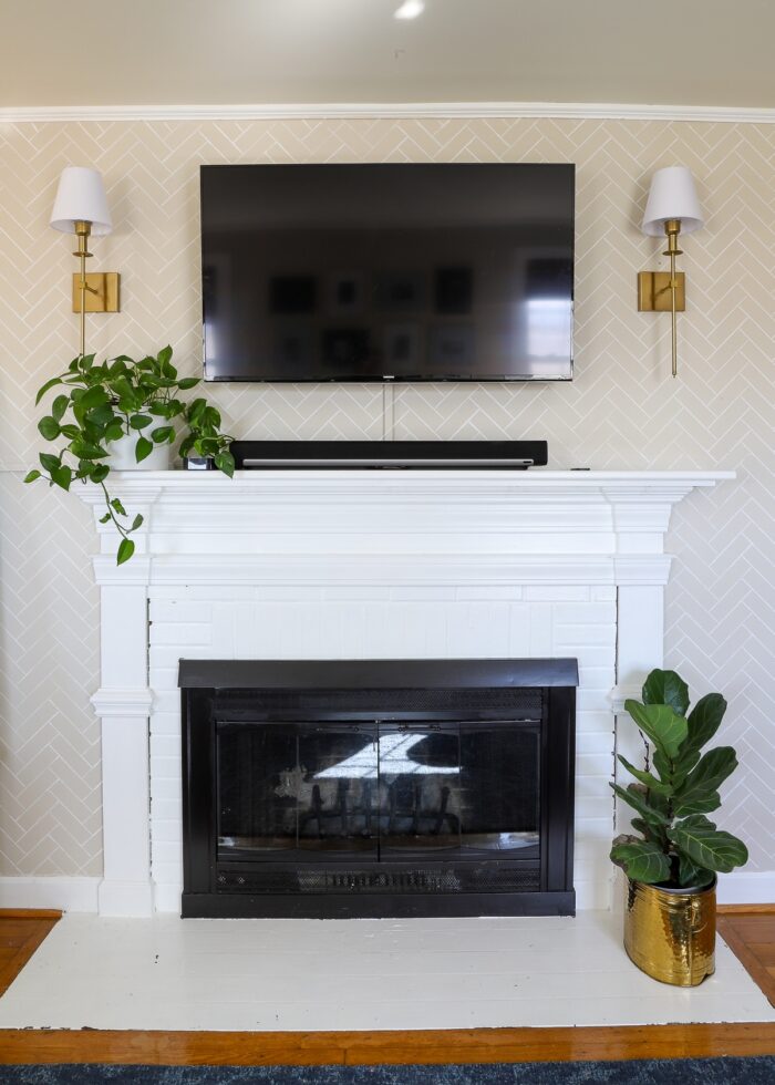 Rental fireplace painted white against a tan wall with fireplace mounted above