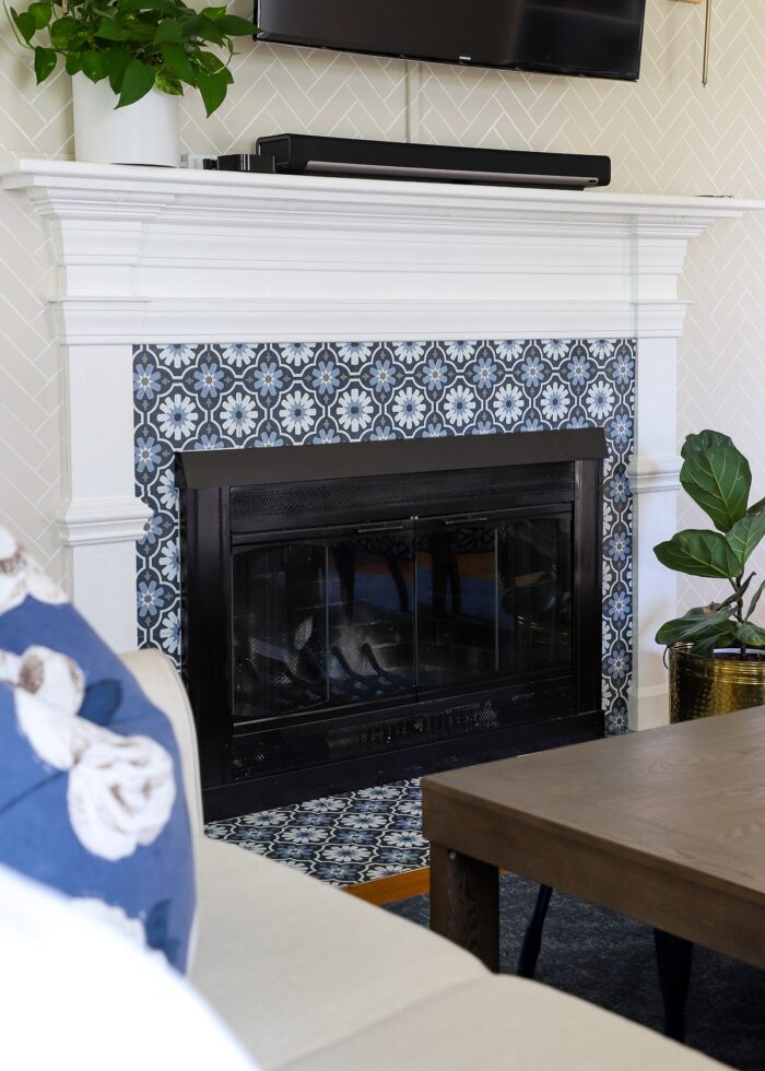 Rental fireplace brick surround and hearth covered in blue and white peel and stick floor tiles