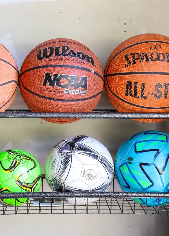 Basketballs and soccer balls on a sports equipment storage rack