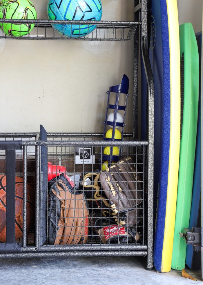Baseball equipment inside a sports equipment storage rack along a garage wall