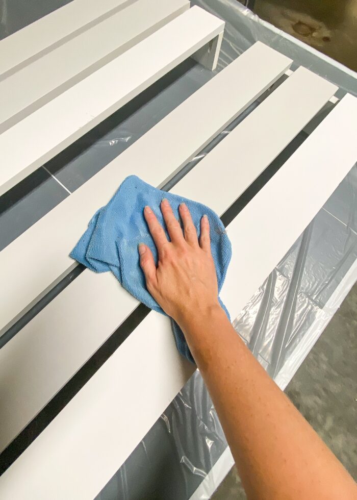 Hands wiping down wood slats on wood valance