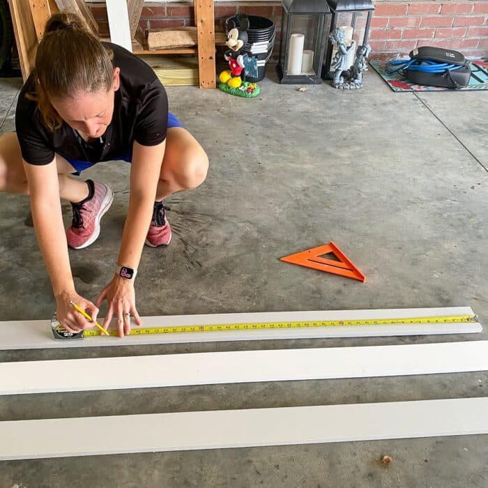 Megan measuring wood boards with a tape measure
