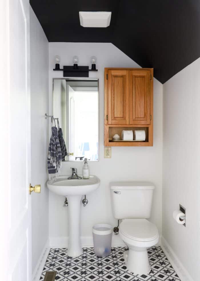 Rental powder room with modern matte black vanity light fixture