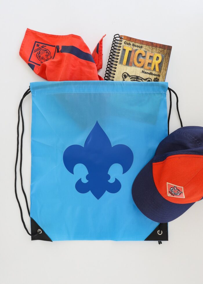 Blue backpack with Scout symbol shown alongside Tiger Cub Scout supplies