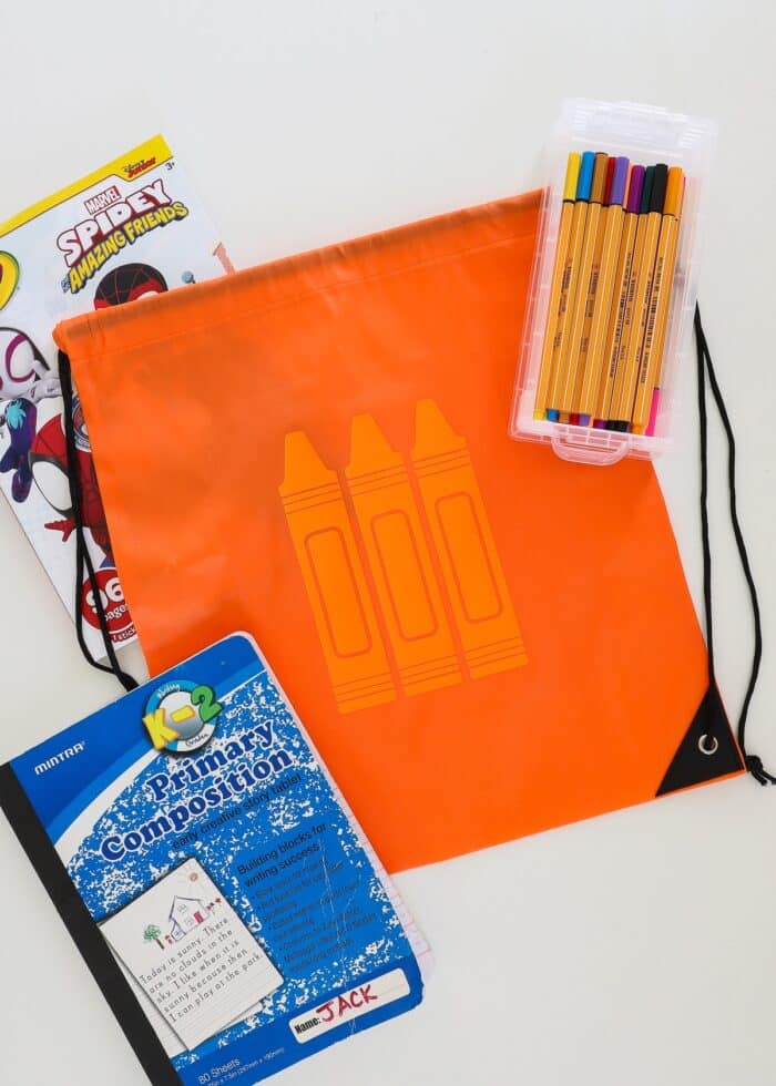 Orange backpack with crayon icon shown alongside art supplies
