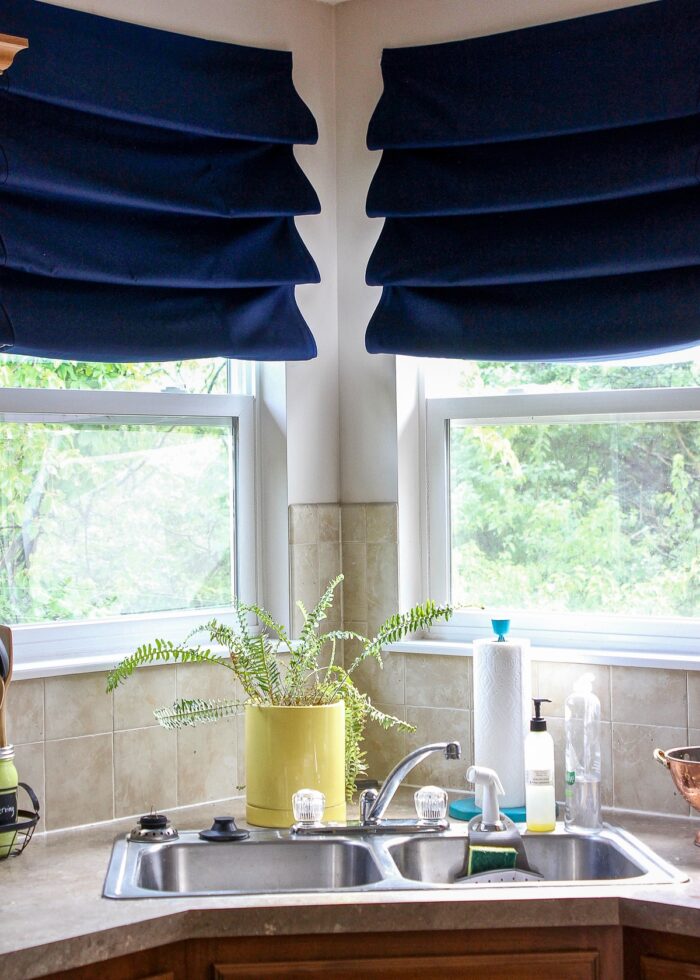 Navy blue window valances on a kitchen window above the sink
