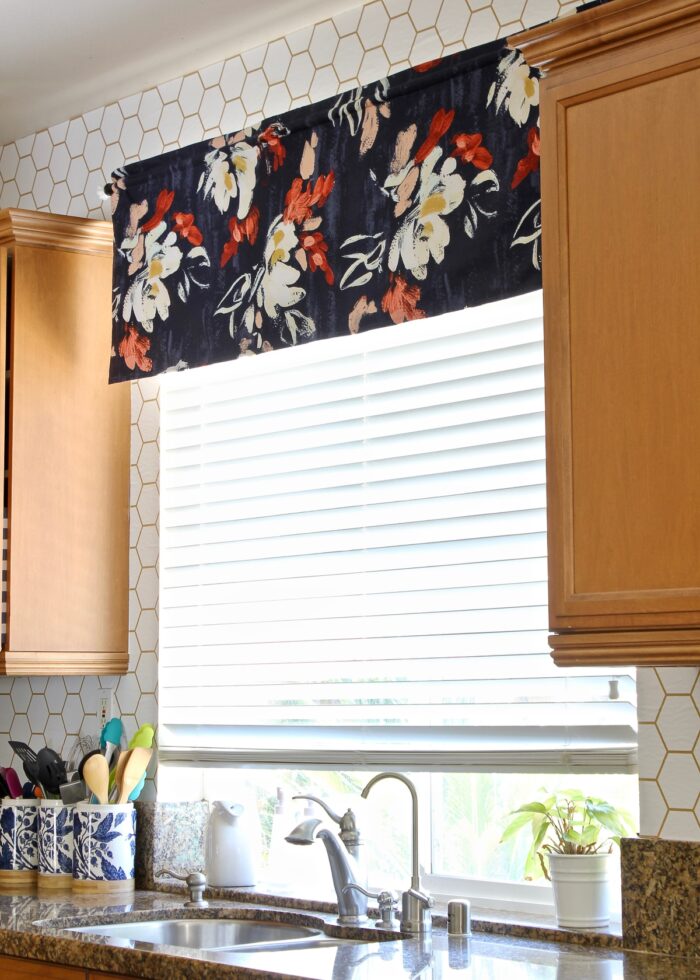 Flowered fabric valance hung on a rod above a kitchen sink