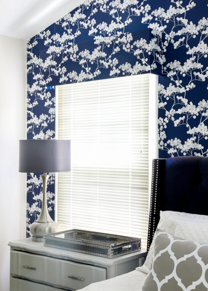 Foam board window valance covered in blue flowered wallpaper and hung on a bedroom window