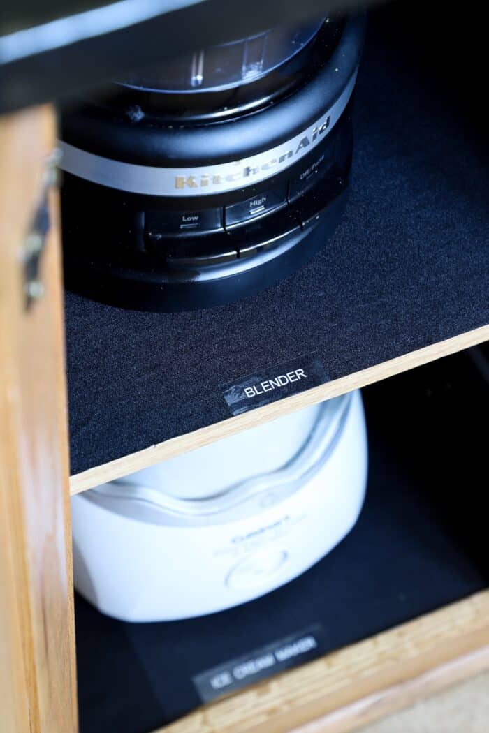White appliance labels on top of black shelf liner