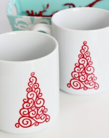 White coffee mugs with red vinyl Christmas tress on the front