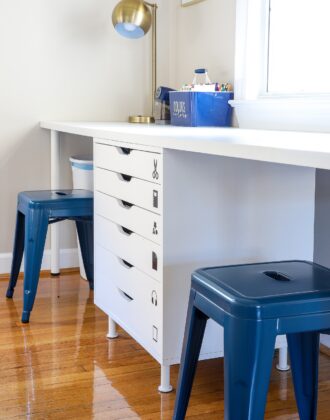 White kids art table with two blue stools