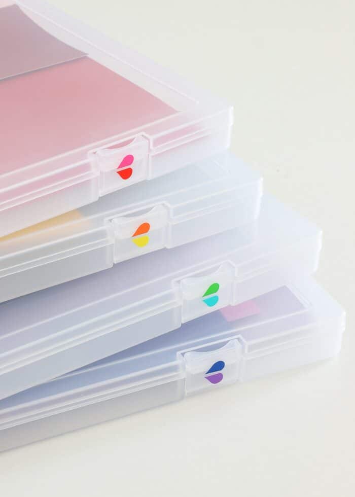 Clear paper storage boxes labeled with rainbow vinyl hearts