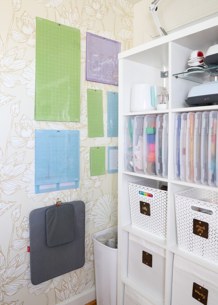 Corner of a craft room with Cricut cutting mats organized and hung on the wall.
