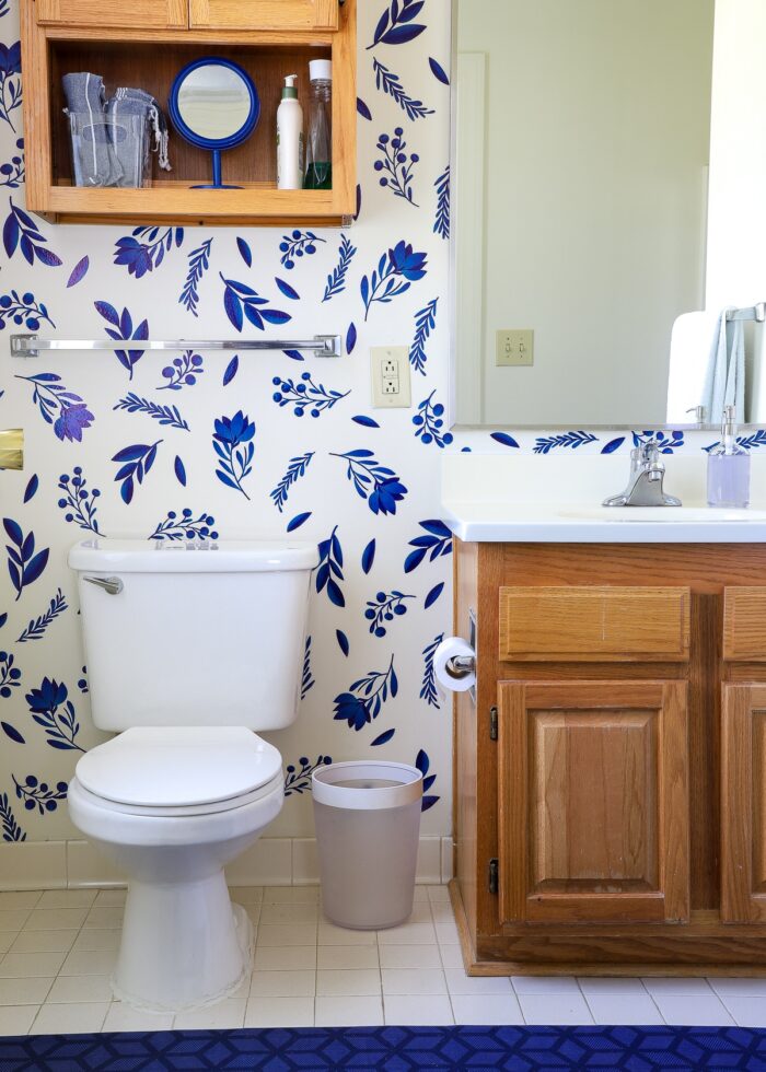 Rental bathroom decorated with blue flower bathroom wall decals and blue mat