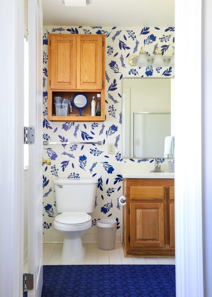 Rental bathroom decorated with blue flower bathroom wall decals and blue mat