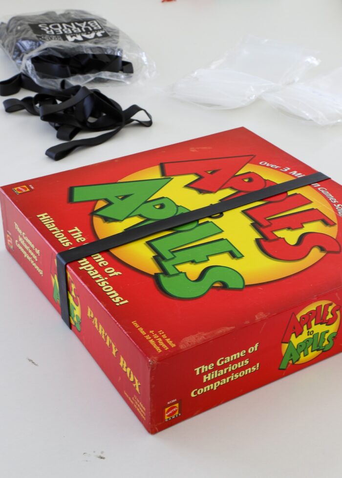 Apples to Apples game held shut with a larger black rubber band