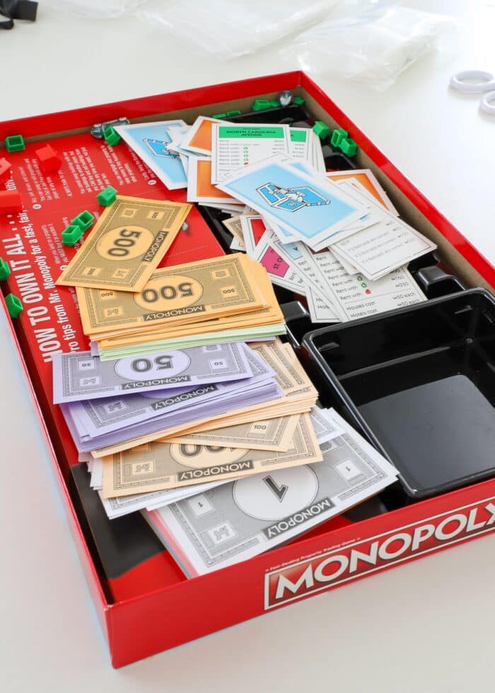 Monopoly game pieces all a mess inside the box