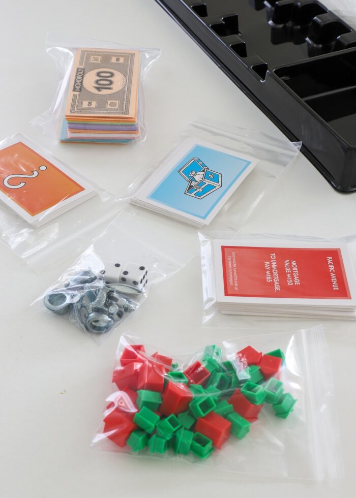 Sorted and organized Monopoly game pieces into small plastic bags