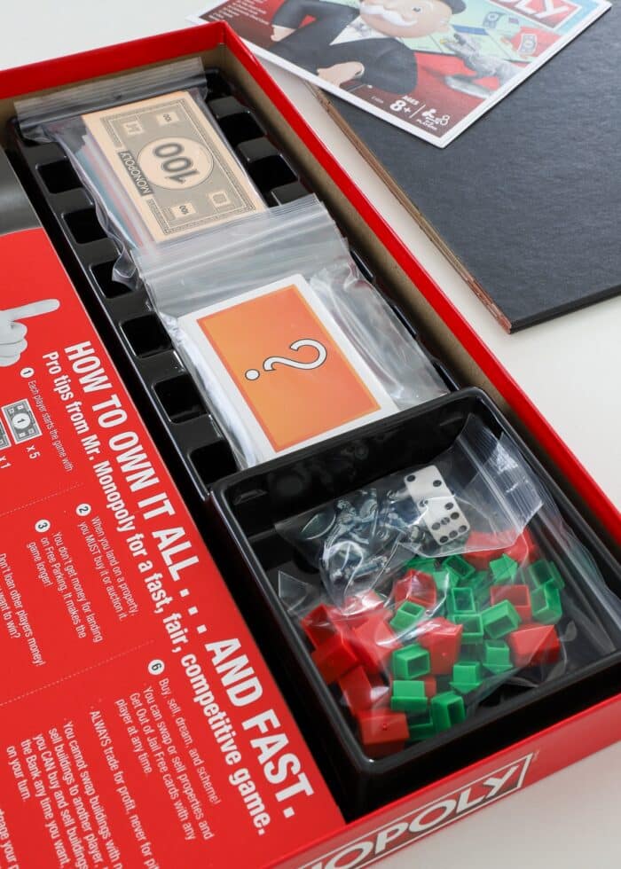 Monopoly game pieces sorted and organized inside the box