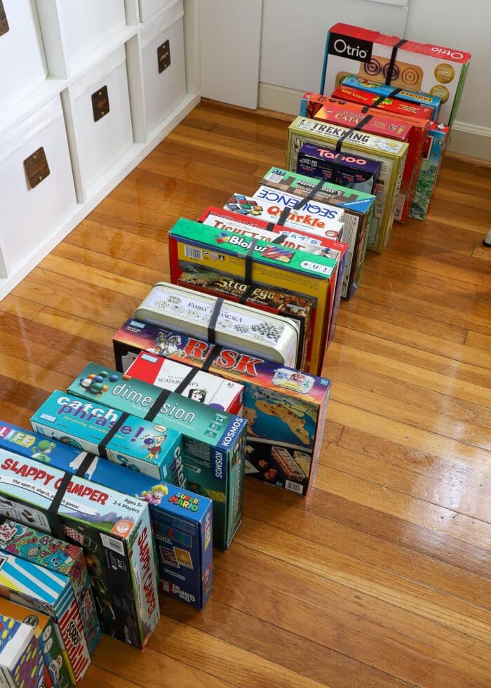 An entire board game collection standing on their sides with rubber bands holding them shut