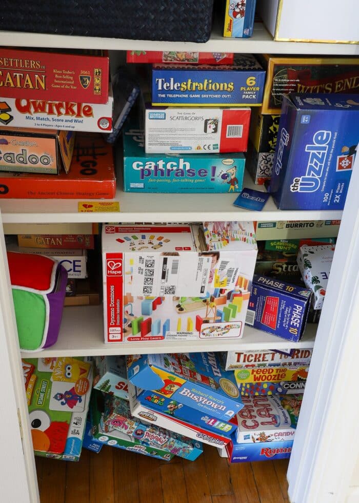 Messy game closet with stacks and stacks of disorganized board games