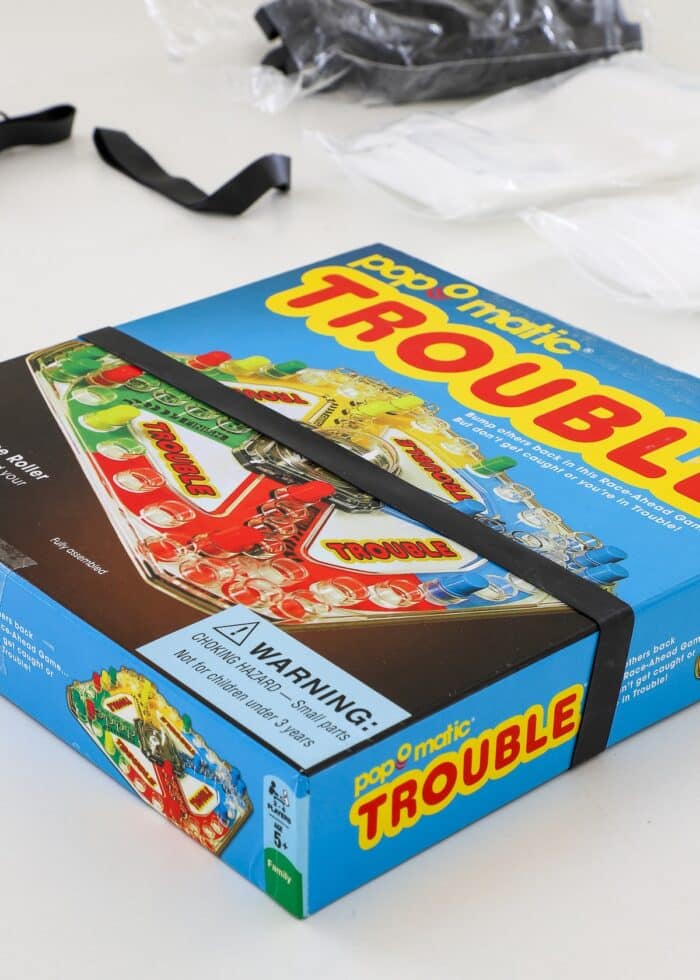 Trouble board game with a larger rubber band around it