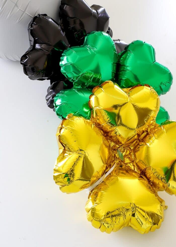 Ribbons strung through the center of a gold clover balloon