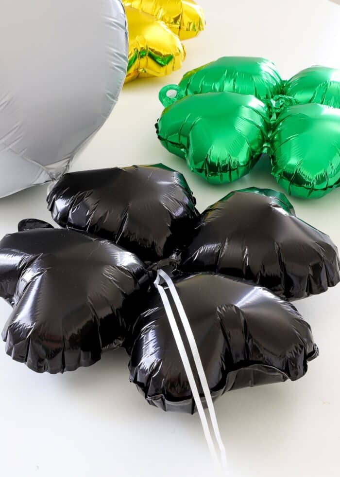 Ribbons strung through the center of a black clover balloon