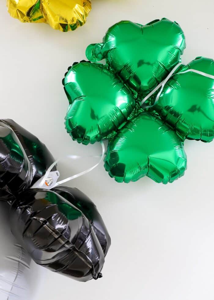 Ribbons strung through the center of a green clover balloon