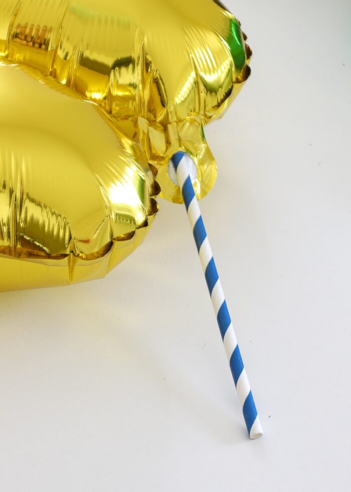 Straw inserted to valve on mylar balloon