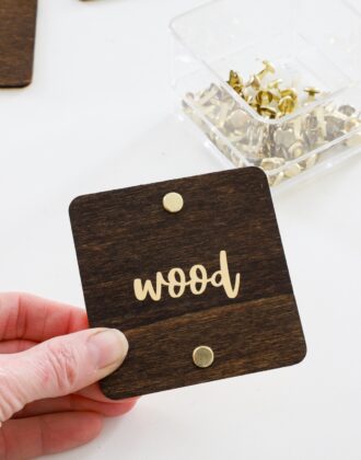 Hand holding wood label with gold foil text in vinyl