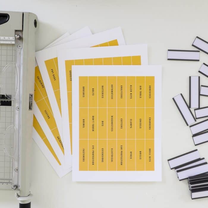 Printed toolbox labels on white paper shown with paper trimmer and magnetic label holders