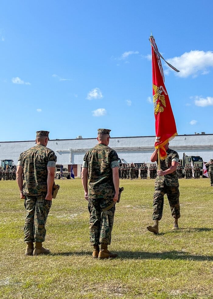 Three US Marines with a Marine Corps flag