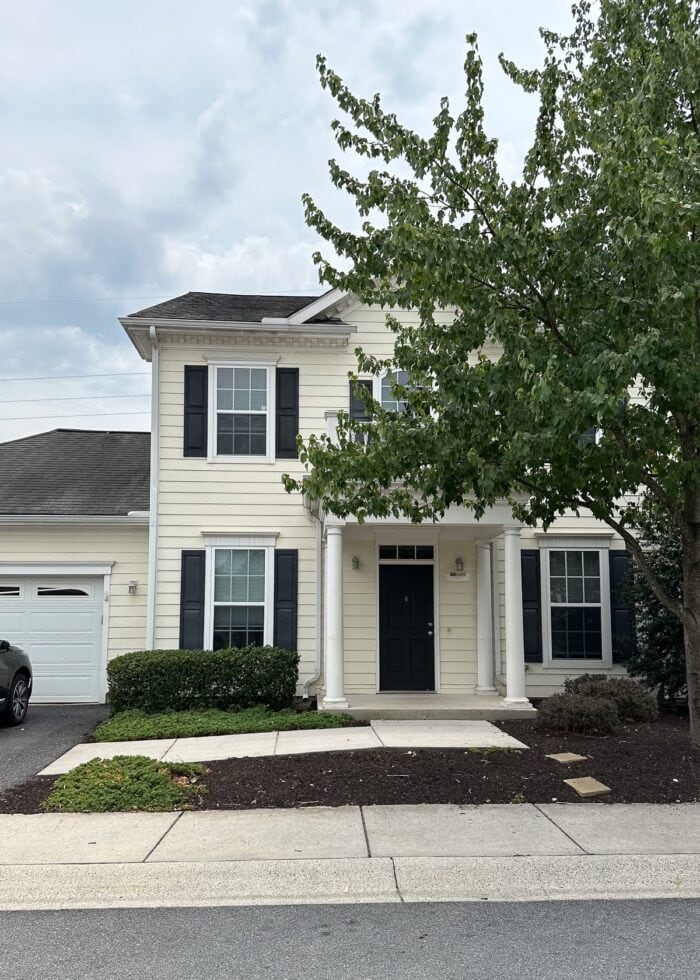 White duplex with a green tree out front