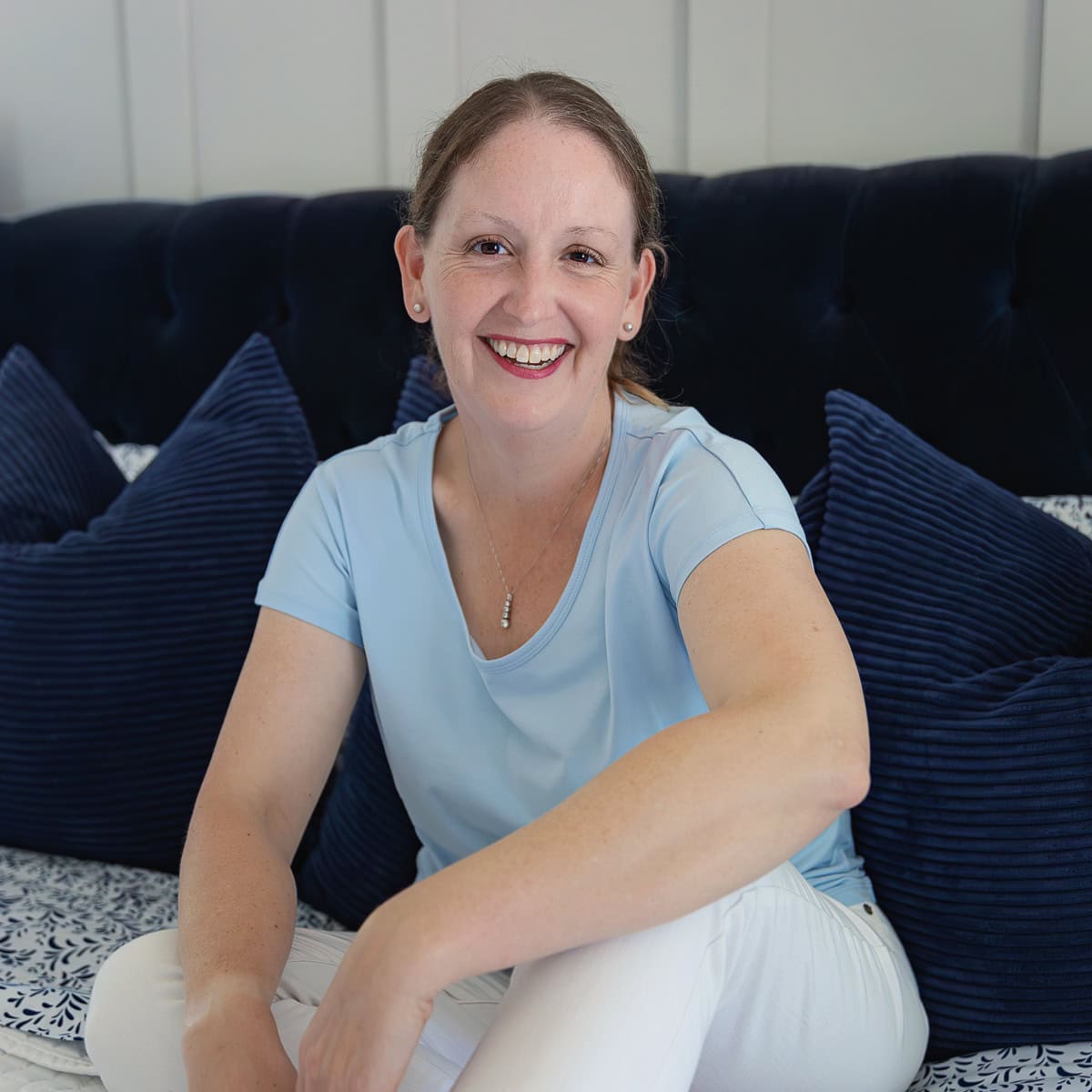 Megan sitting on blue bed