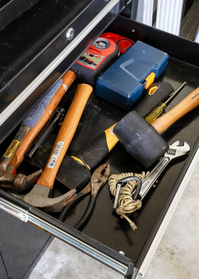 Black rolling toolbox with hammers inside the drawer