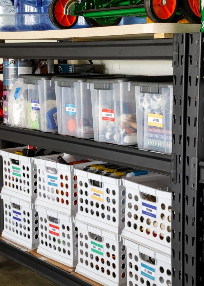 Storage shelves in a garage holding clear bins and crates