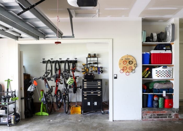 Side of an organized garage showing a nook holding bike storage and tools