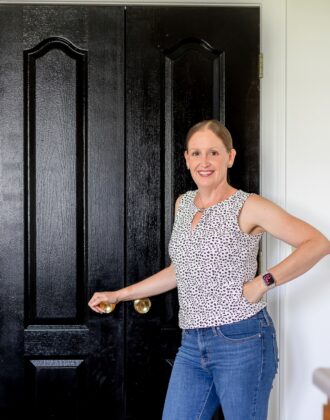 Megan from The Homes I Have Made standing in front of black pantry doors