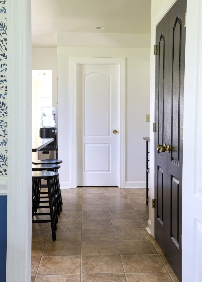 All white kitchen with black pantry doors