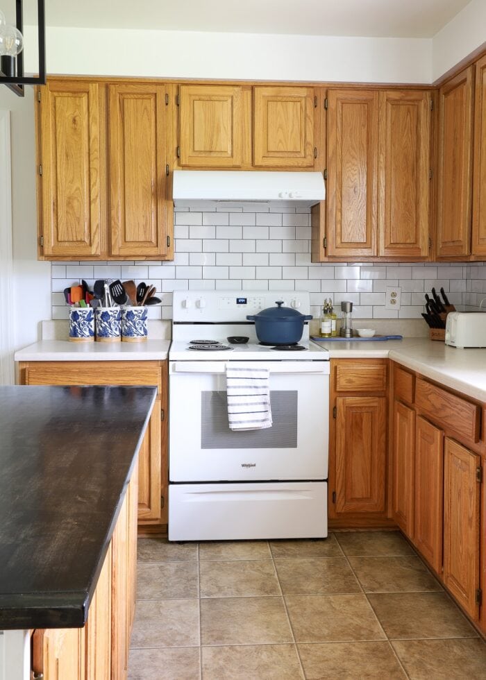 While peel and stick subway tile on the backsplash above a stove in rental kitchen