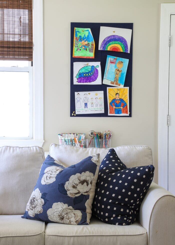 Children's art pinned up in a blue and white living room