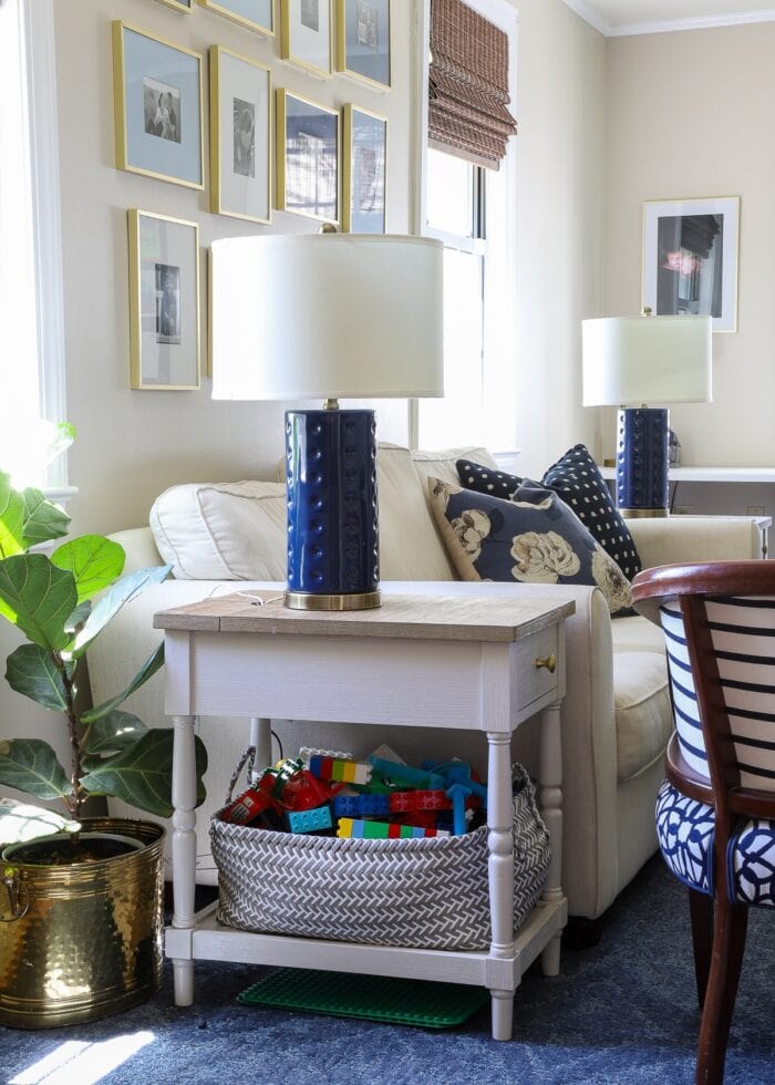 A basket of blocks underneath a side table in a stylish living room