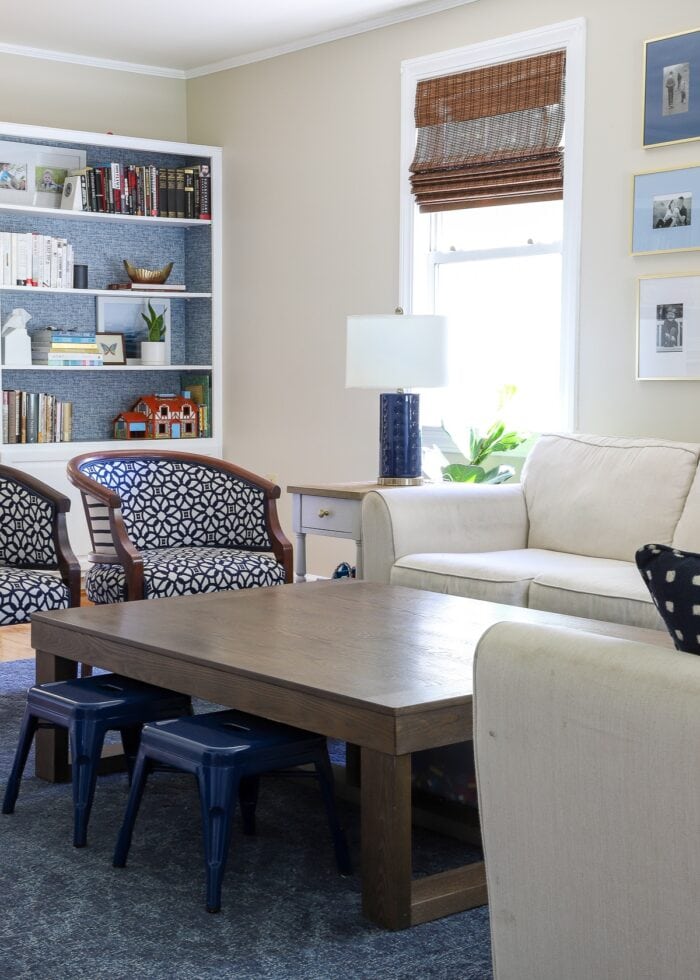 Blue and white family room with large coffee table, white couch, and two decorative chairs