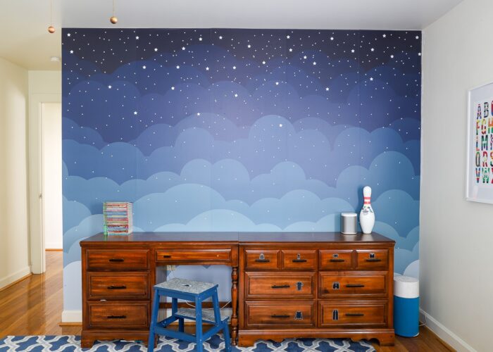 A blue night sky mural on a boys' shared bedroom wall